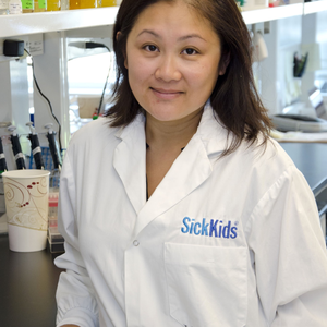 Picture of doctor wearing white coat with sick kids hospital logo in blue